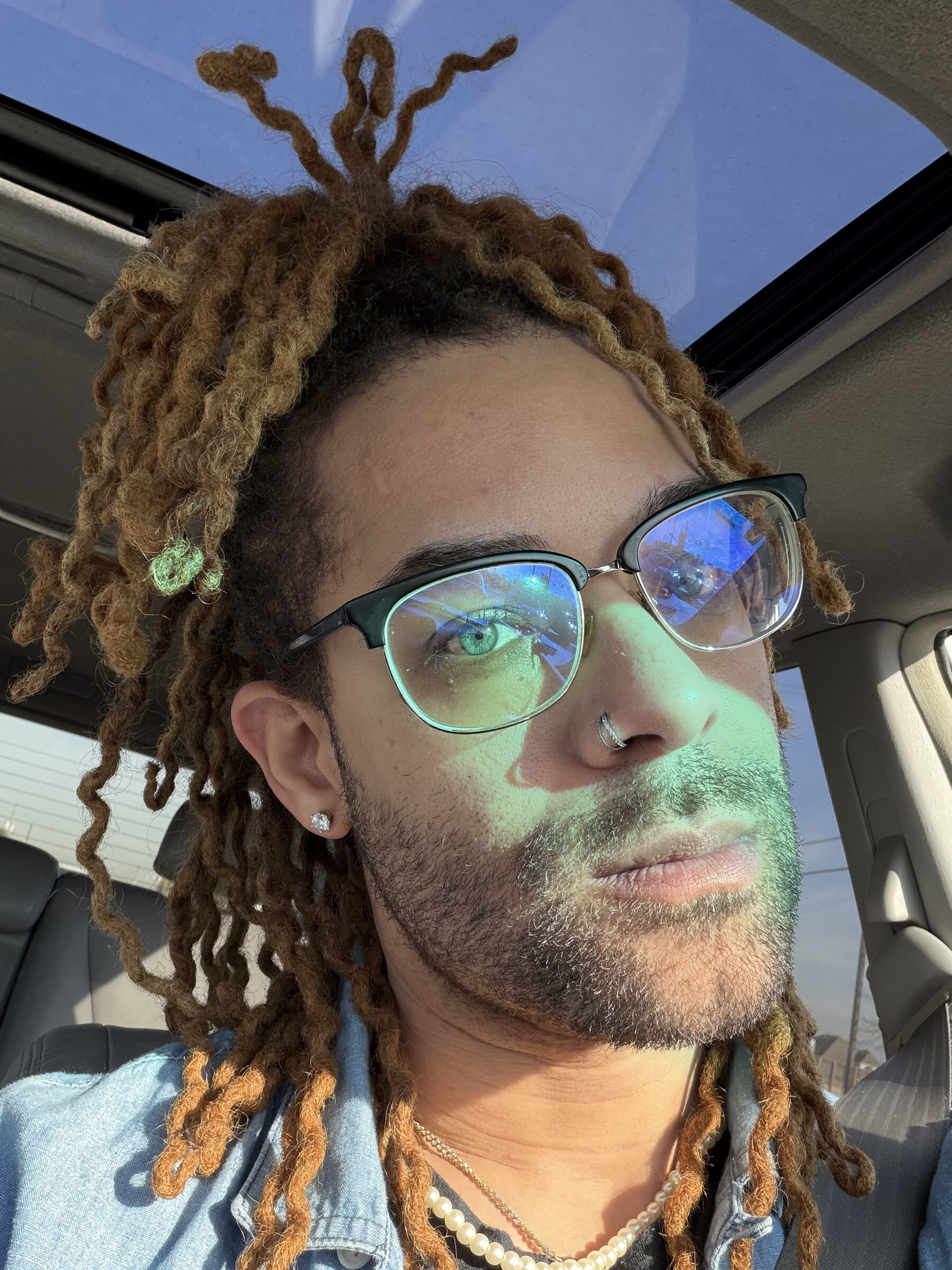 A close portrait of Stoney wearing gold glasses