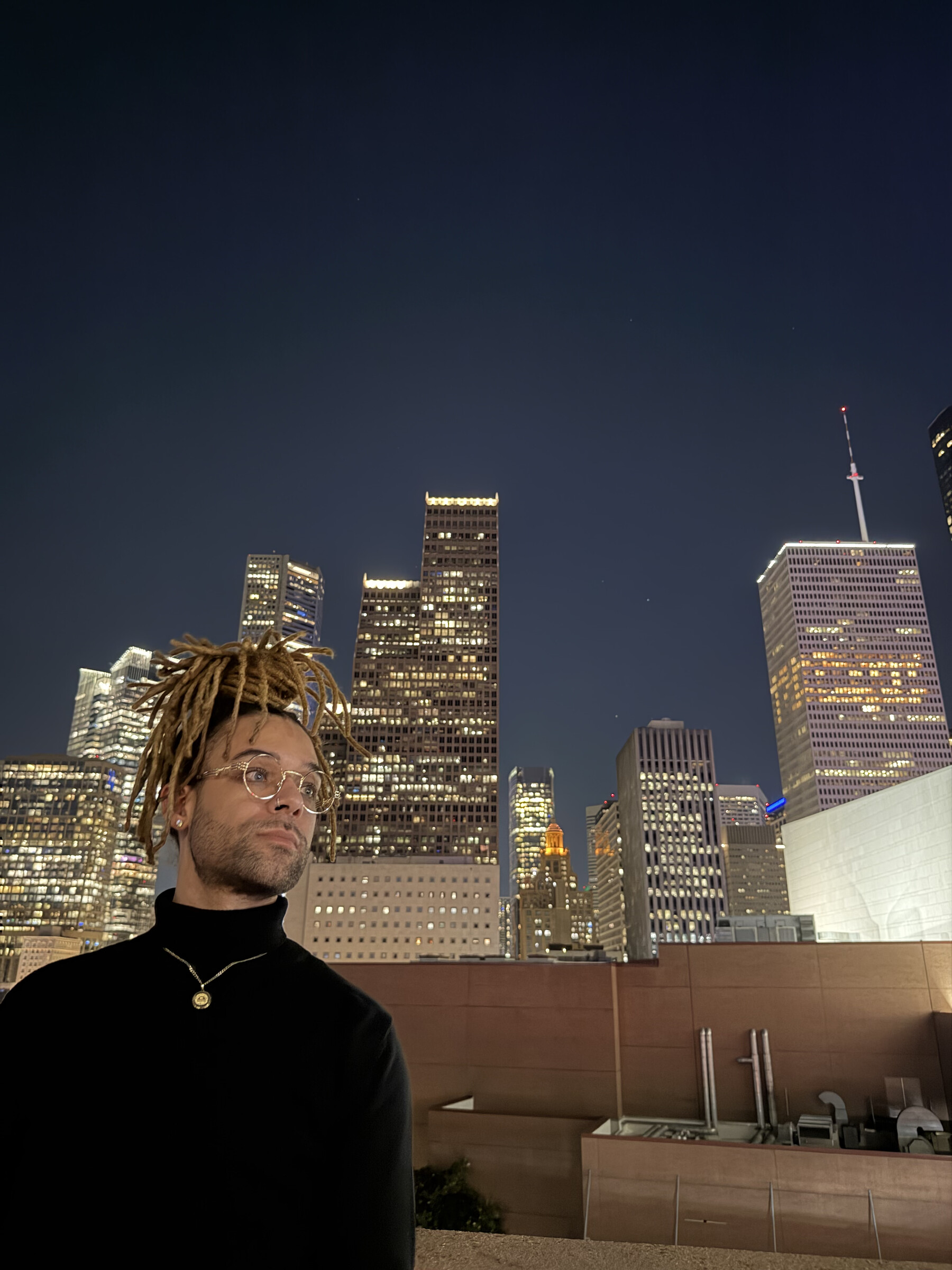 Stoney standing against a city skyline at night
